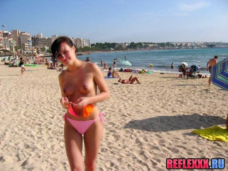 Сняв лифчик, с голыми сиськами по пляжу