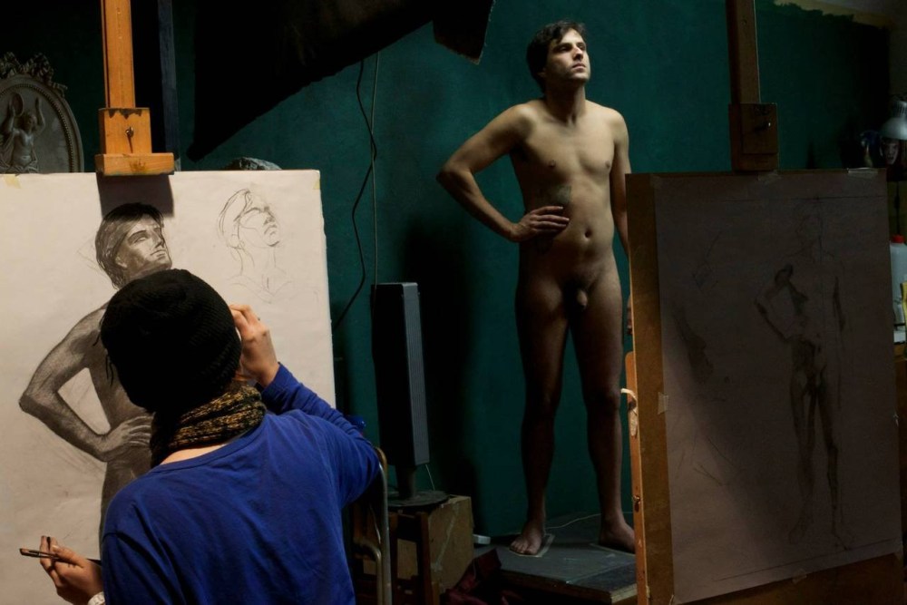 Голый мужчина позирует художнице