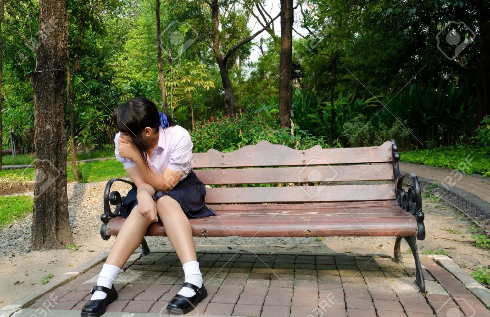 Женщина плачет на скамейке